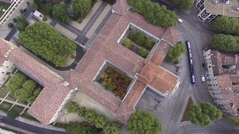 Vista-Vertical-Aérea-De-Drones-Sobre-Un-Tranvía-Y-Un-Antiguo-Edificio-Histórico.